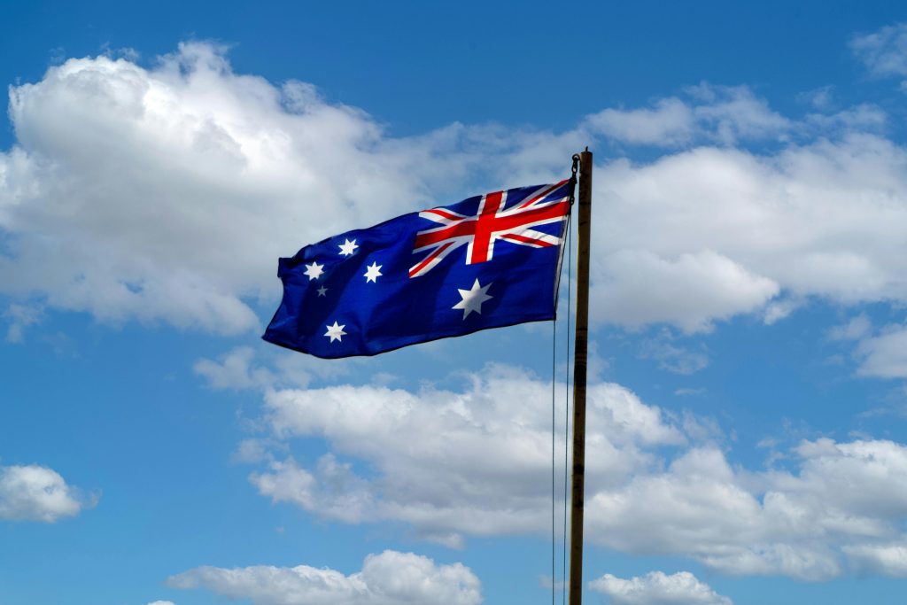 Australian flag waving against clear blue skies symbolizing national pride and freedom.