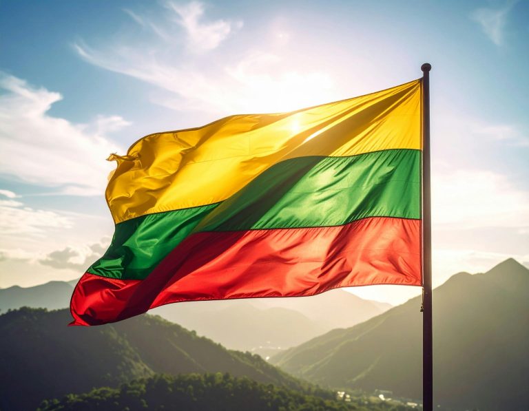 Vibrant Lithuanian flag waving against a mountainous backdrop and a bright sky.